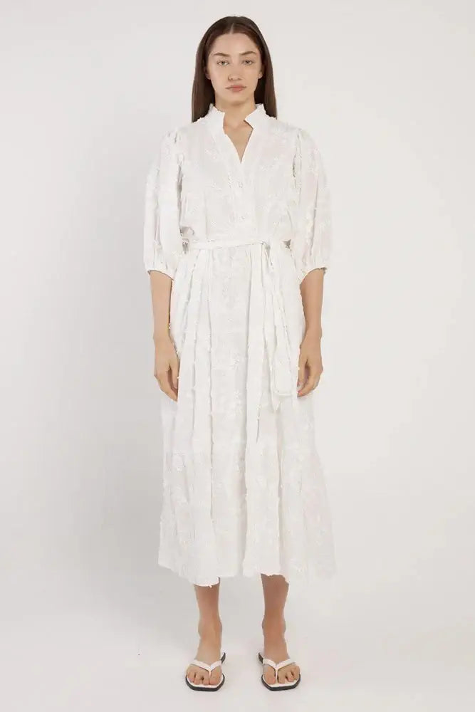 Woman wearing a white dress on a plain background