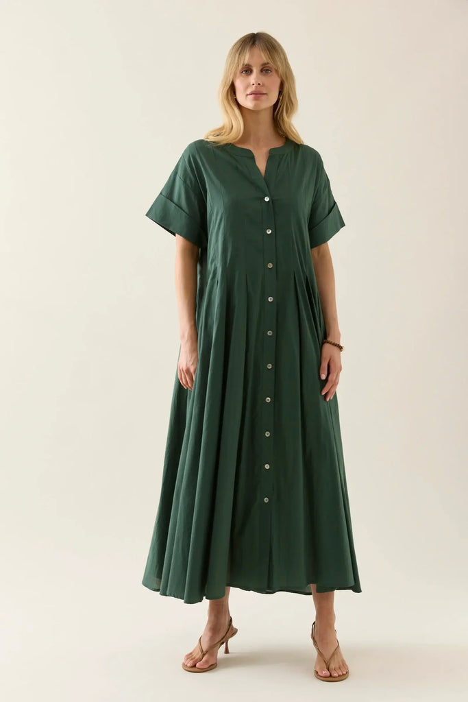 Woman wearing a green dress with buttons on a white background