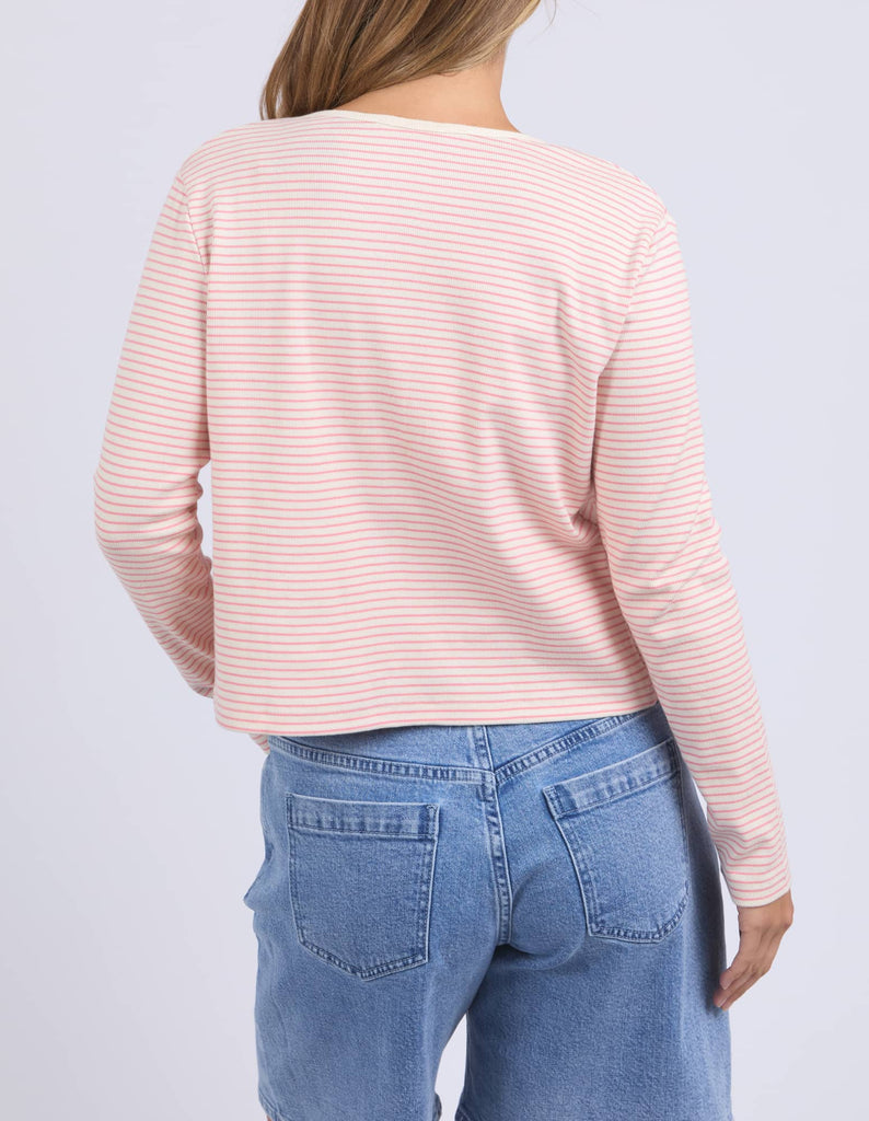 Person wearing a pink striped long-sleeve top and blue jeans on a light gray background