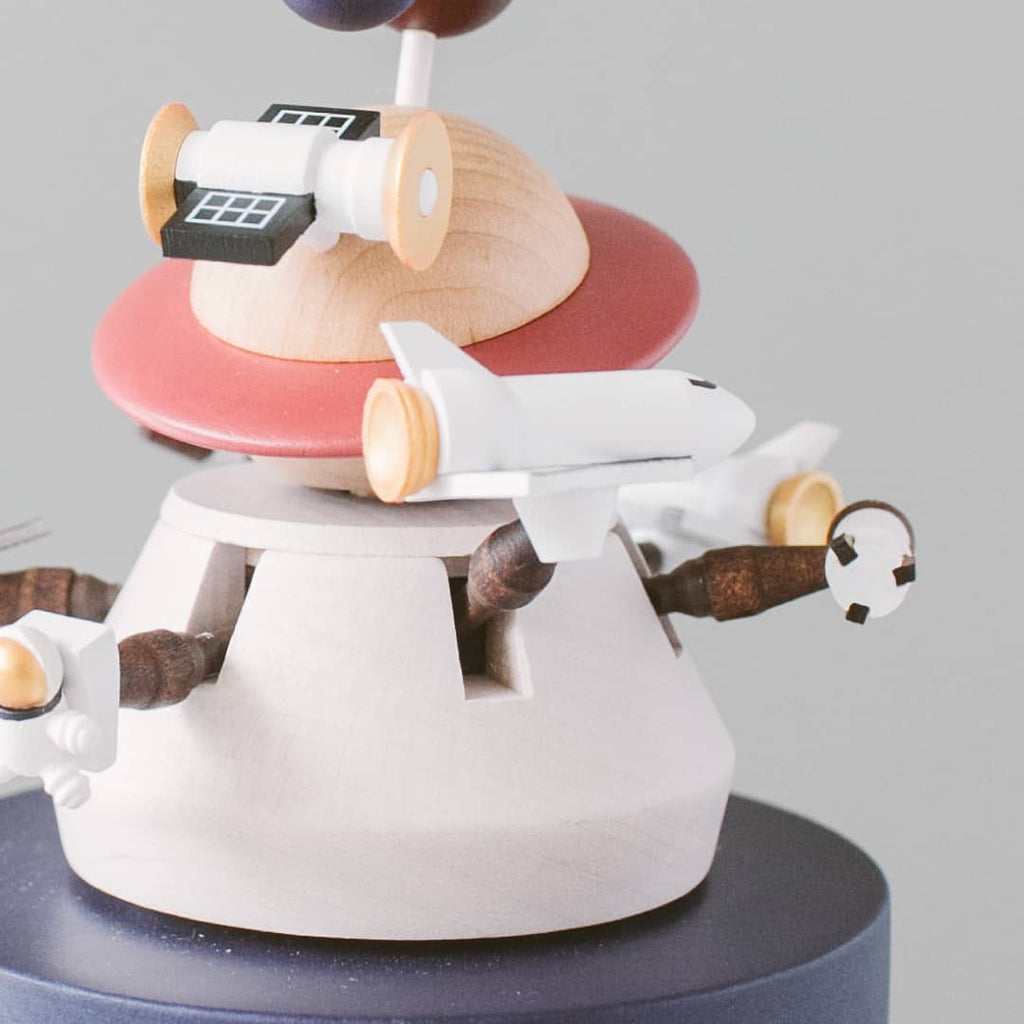 Toy airplane on a spinning wooden toy with various shapes and colors.