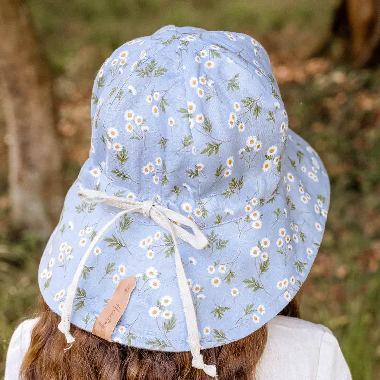 Light blue floral patterned sun hat worn by a person with a blurred natural background