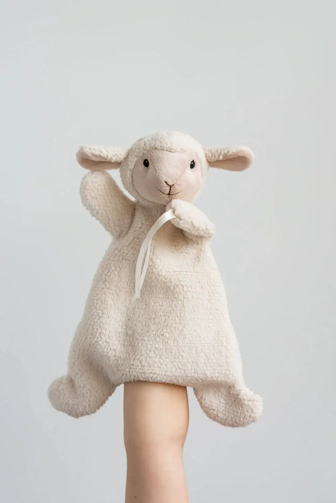 Stuffed toy sheep in a beige outfit on a white background