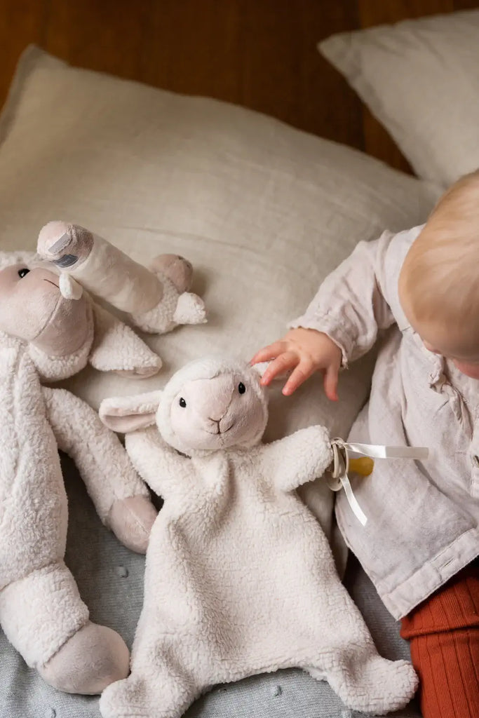 Child playing with plush toys on a cushion