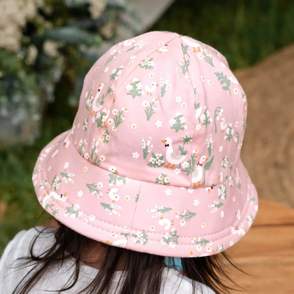 Pink floral-patterned bucket hat worn by a person outdoors.